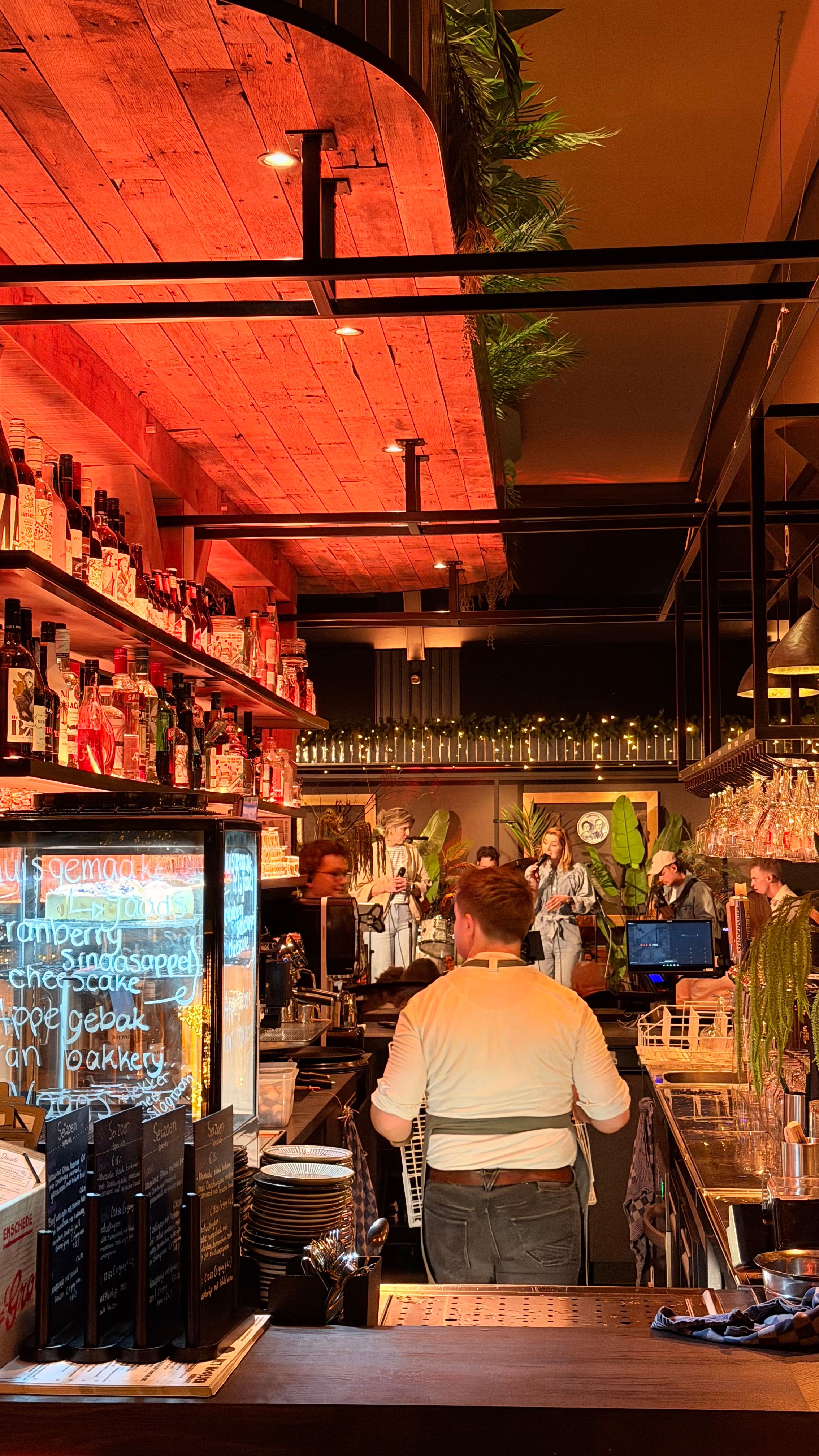 Bediening achter de bar, met de band op de achtergrond