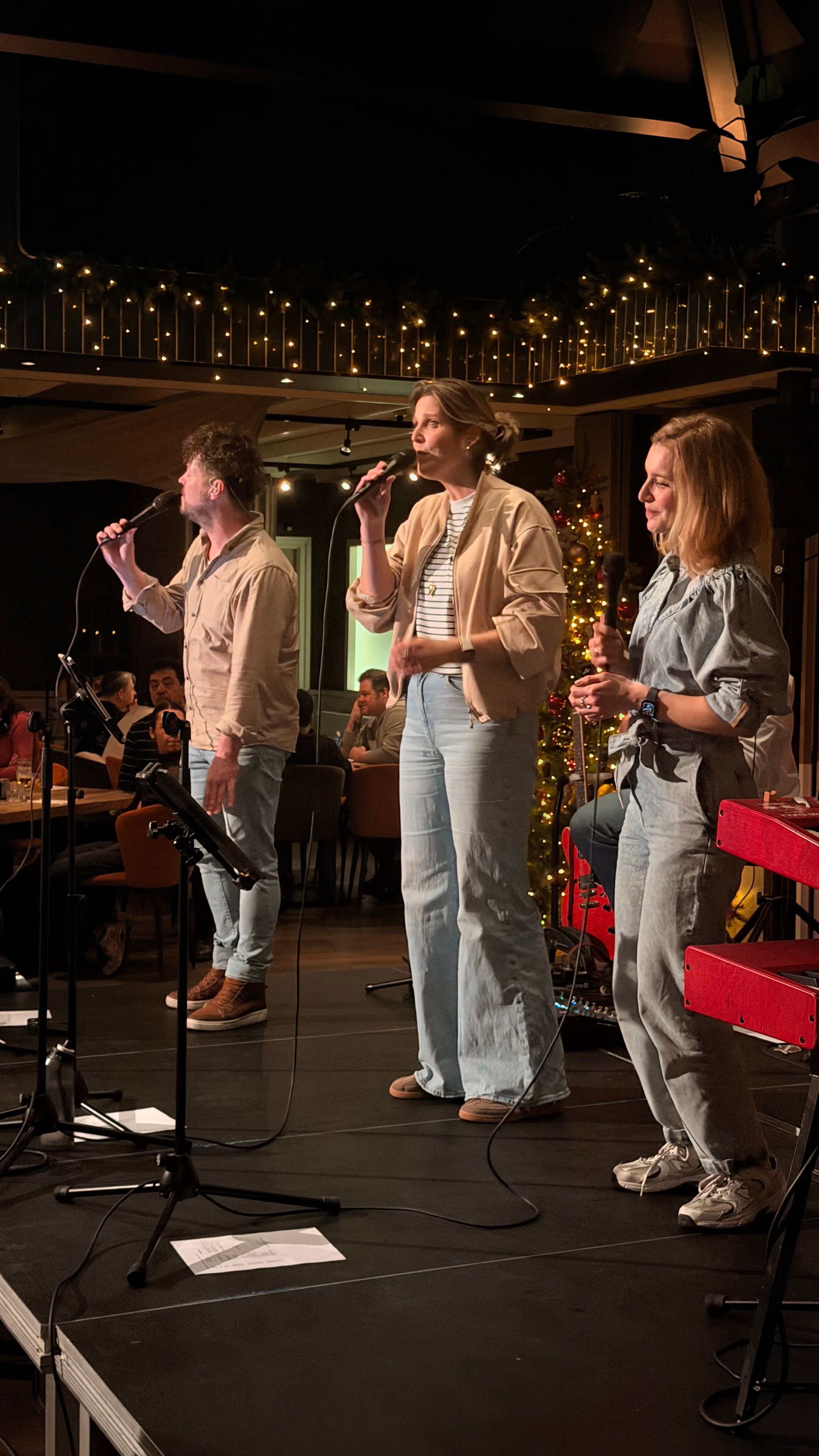 Drie zangers van de band op het podium tijdens de dinnershow in 't Noorden
